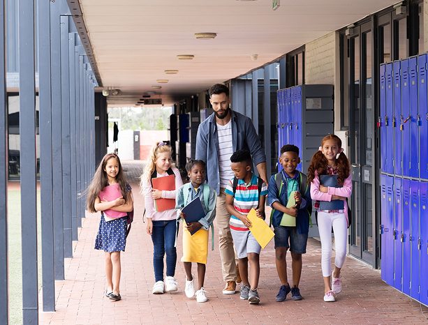 Teacher walking with students down a school hallway